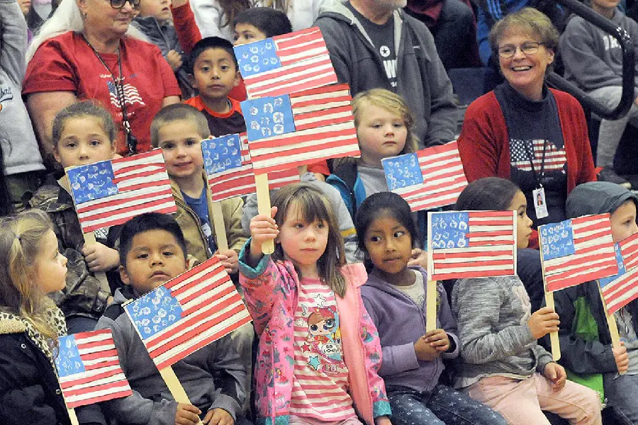 Kids carrying the American flags in honor of the military on the occasion of Veterans Day