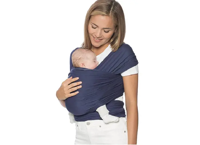 A new mother carries her baby in a solid blue color baby wrap. 