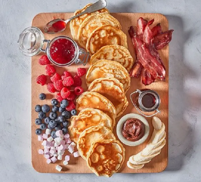 Beautifully presented pancakes and bacons with other fruits and add-on for a Mother's Day brunch. 