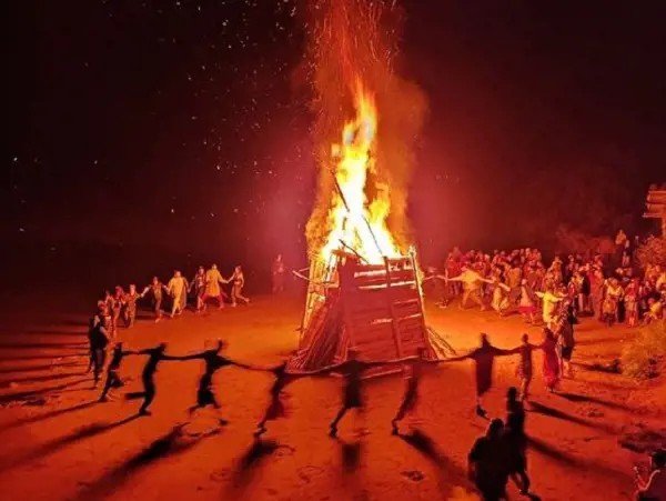 People dance around a huge bonfire to celebrate Litha in traditional style.