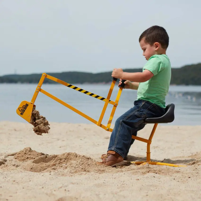 A young child shows off his digging skills with a big dig excavator
