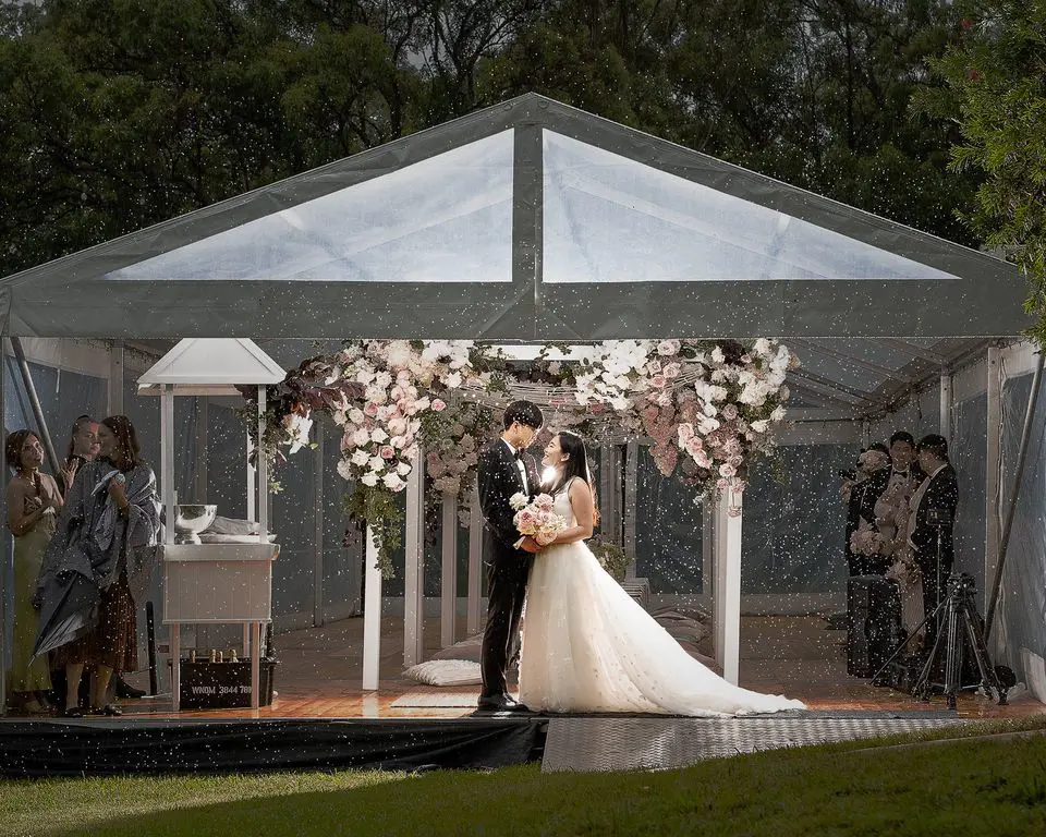 Couple Charlie and Jessica pictured at a beautiful wedding venue during spribnkiling rain. Captured By: William Gordon Photography