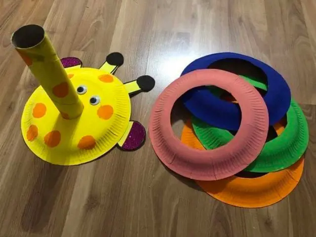 Colourful paper plate rings are cut out and ready to be tossed at the yellow colored paper poll