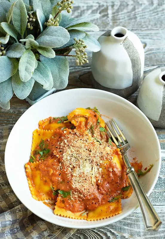 A delicious serving of Ravioli presented in a white bowl.