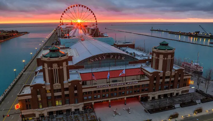 An ariel view of Navy Pier where the iconic Centennial Wheel is seen in the background during sunset. 