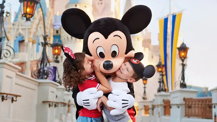 Two kids hug the famous Disney character Mickey Mouse at Walt Disney World