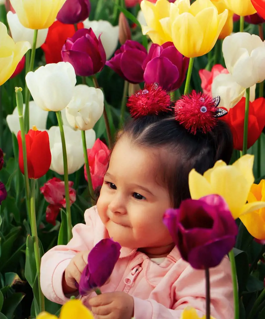 A darling girl nestled among nature beauty finding wonder and delight in the tulip garden