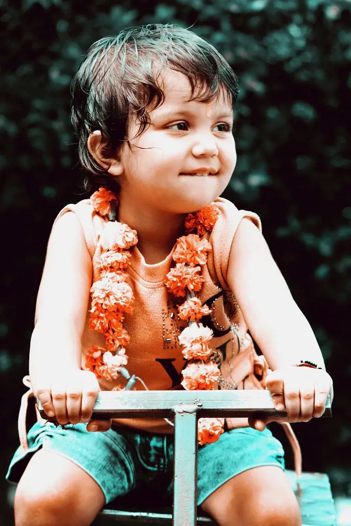 Adorned with a marigold garland this little girl radiates joy and the vibrant spirit of celebration
