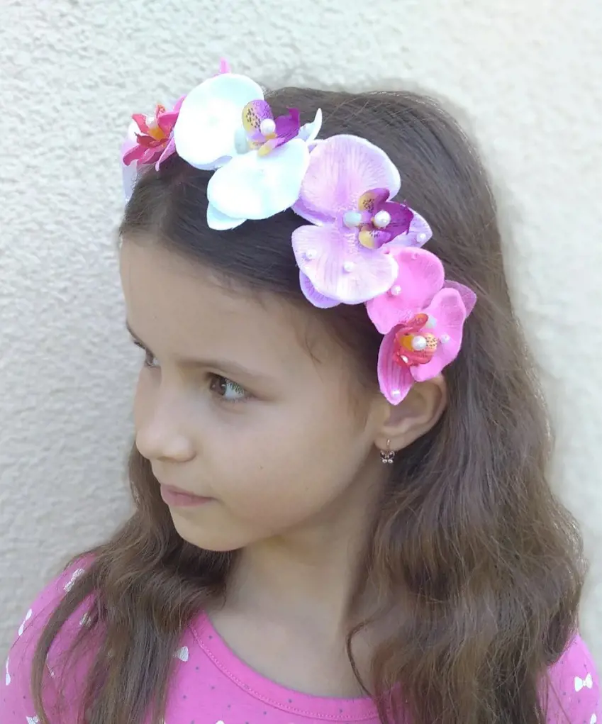 Wearing a stunning orchid headband the beautiful girl hair is adorned with elegance and charm