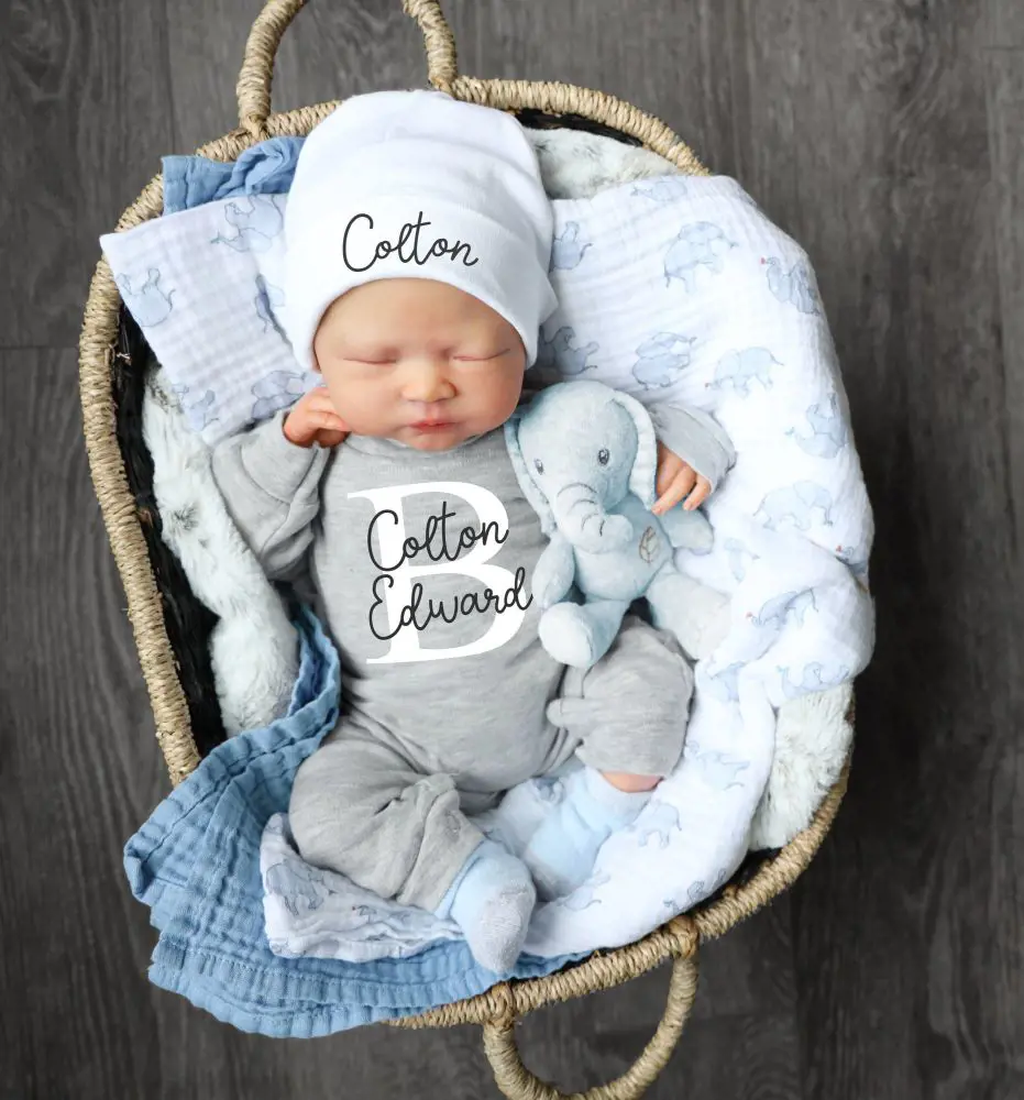 A newborn baby attired in a personalised grey colored onesies