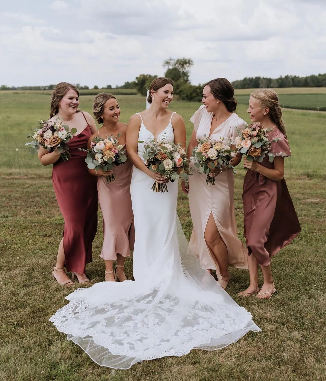 A bride with her maids holding flower bouquets and having some fun time
