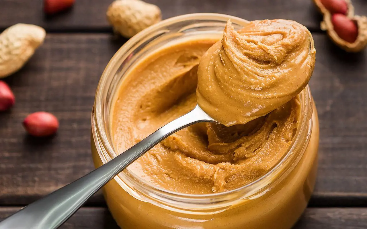 Peanut butter in a jar with spoon