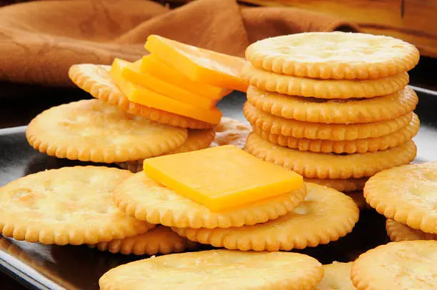 A bunch of crackers with cheese on top
