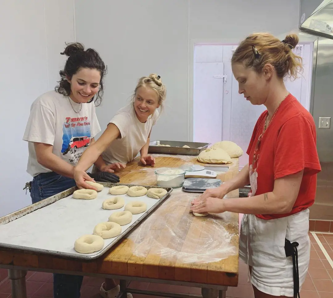 (L-R) Rose, Meave, and Rory work together in the kitchen to prepare bagels at Rory's place.