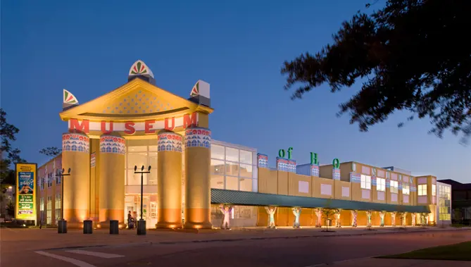 Children's Museum of Houston building pictured at night with all the lights turned on. 